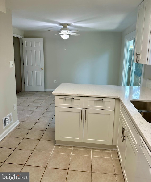 kitchen with light tile patterned flooring, kitchen peninsula, ceiling fan, dishwashing machine, and white cabinets