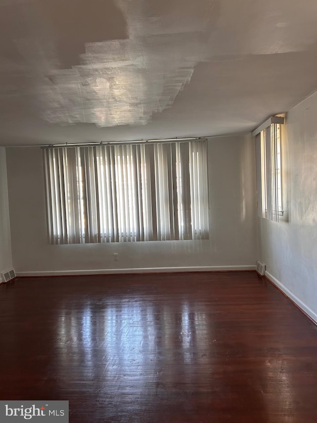 unfurnished room with plenty of natural light and dark hardwood / wood-style floors