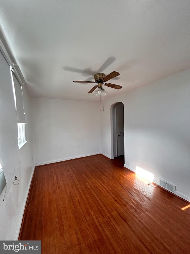 empty room with dark hardwood / wood-style floors and ceiling fan