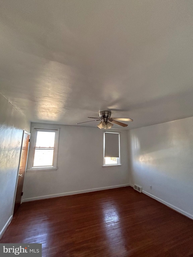 spare room with ceiling fan and dark hardwood / wood-style floors