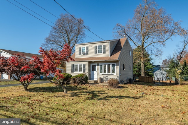 view of front of home with cooling unit and a front lawn