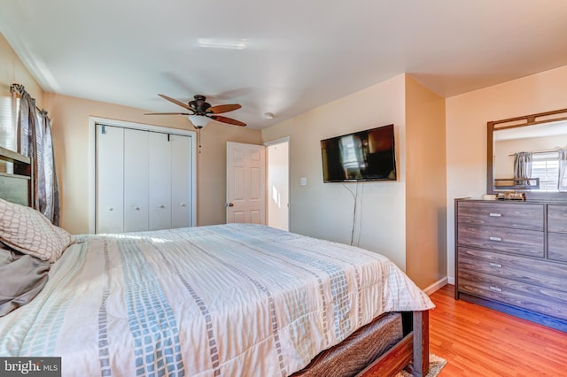 bedroom with light hardwood / wood-style floors, ceiling fan, and a closet