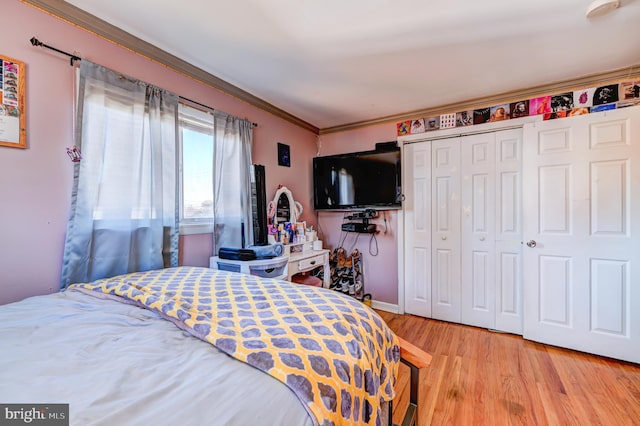 bedroom featuring a closet, wood-type flooring, and ornamental molding