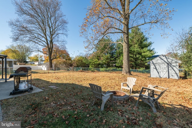 view of yard featuring a shed and an outdoor fire pit