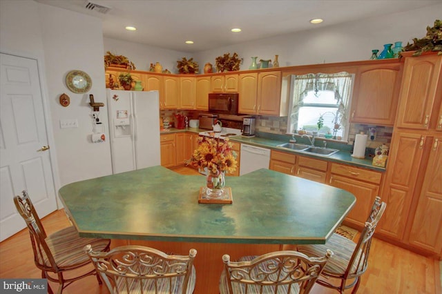 kitchen with sink, light wood-type flooring, backsplash, and white appliances