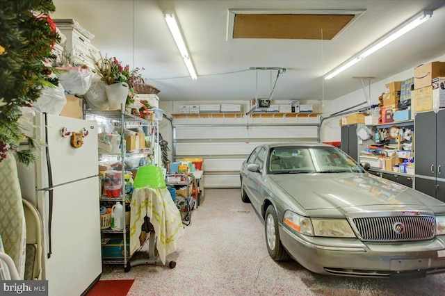 garage with white fridge and a garage door opener