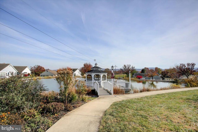 view of dock featuring a gazebo, a yard, and a water view