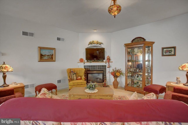 living room with a tiled fireplace and light colored carpet