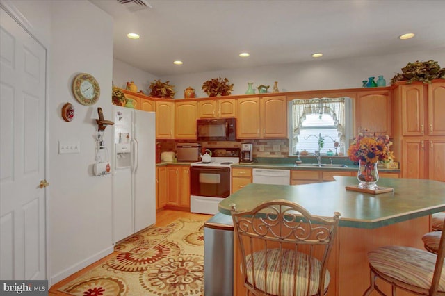 kitchen featuring a kitchen island, decorative backsplash, light hardwood / wood-style floors, a breakfast bar, and white appliances