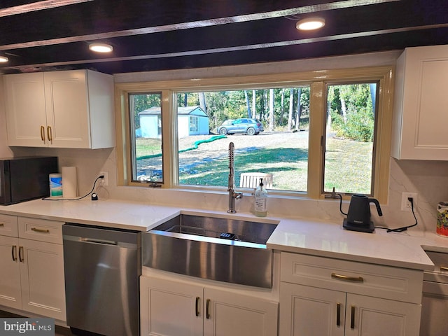 kitchen featuring light stone countertops, sink, white cabinets, and stainless steel dishwasher