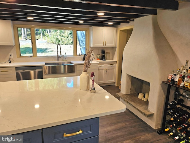 kitchen featuring white cabinets, sink, stainless steel dishwasher, dark hardwood / wood-style floors, and blue cabinetry