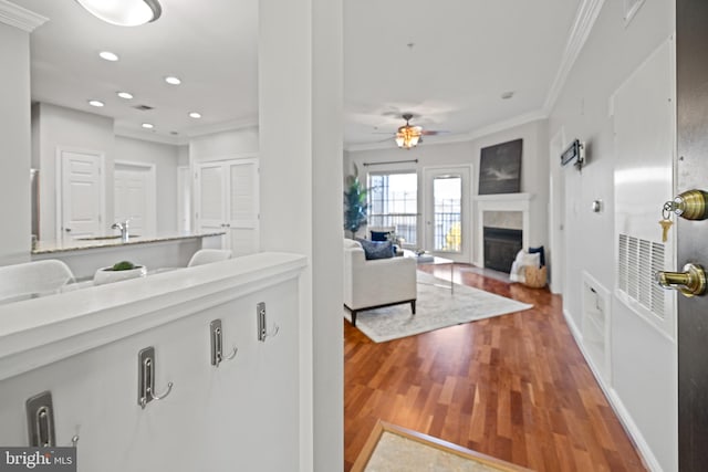 kitchen with crown molding, wood-type flooring, and ceiling fan