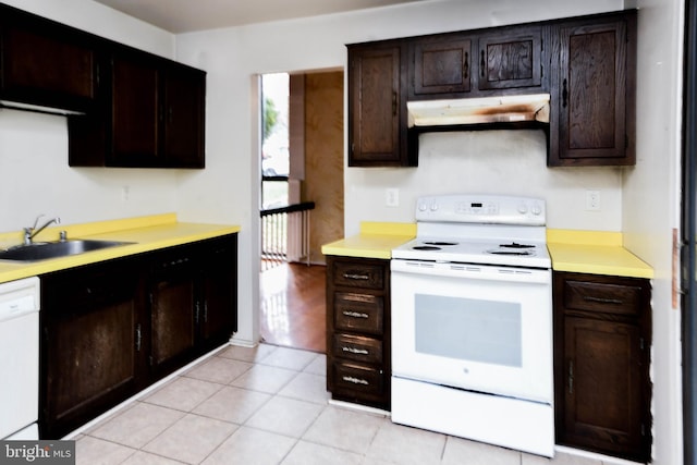 kitchen featuring light tile patterned floors, white appliances, dark brown cabinetry, and sink