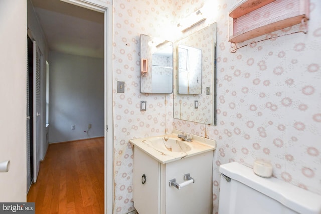 bathroom featuring wood-type flooring, vanity, and toilet