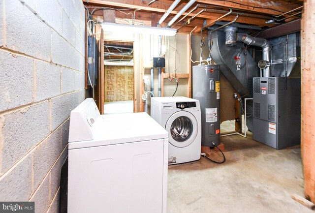 clothes washing area featuring electric water heater and separate washer and dryer