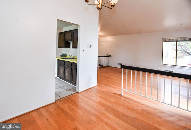 empty room featuring a chandelier, light hardwood / wood-style flooring, and sink