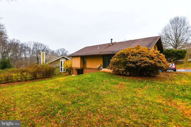 rear view of property featuring a lawn