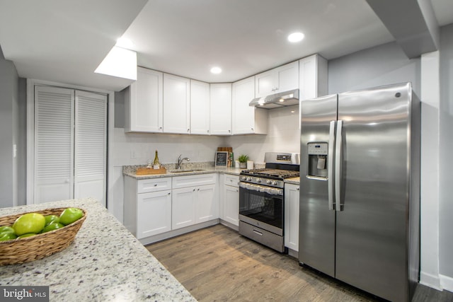 kitchen featuring sink, white cabinets, stainless steel appliances, and wood-type flooring