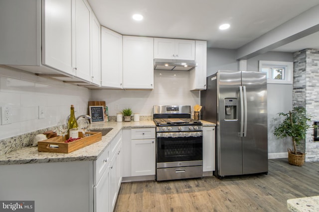 kitchen featuring light hardwood / wood-style flooring, stainless steel appliances, sink, light stone countertops, and white cabinetry