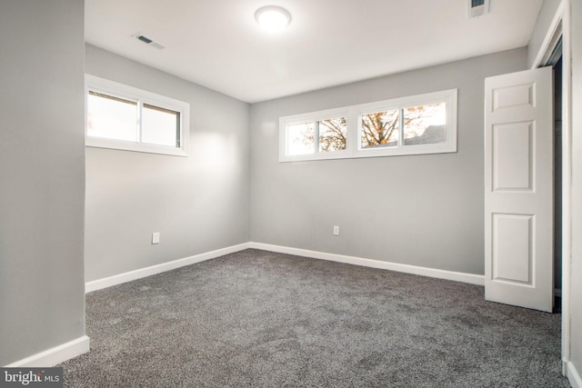 empty room featuring dark carpet