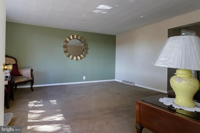 sitting room featuring dark carpet