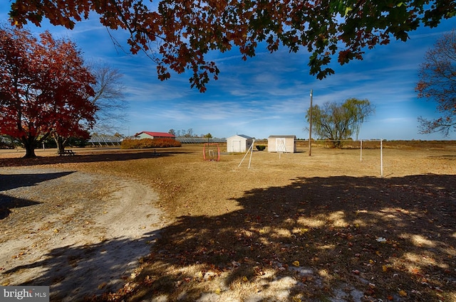 view of yard featuring a rural view and a shed