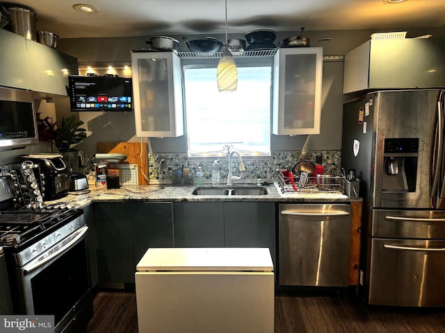 kitchen featuring tasteful backsplash, light stone counters, stainless steel appliances, dark wood-type flooring, and sink