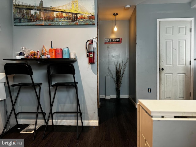 kitchen featuring pendant lighting and dark wood-type flooring