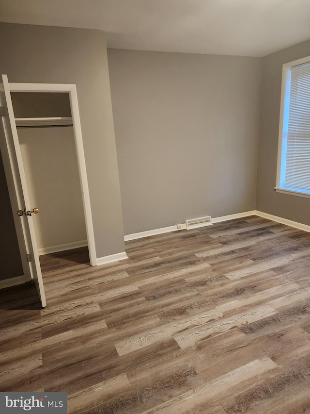 unfurnished bedroom with a closet and hardwood / wood-style floors