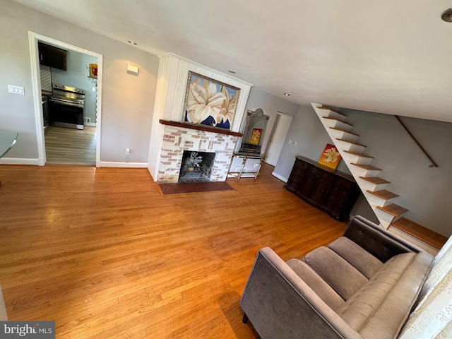 living room with light hardwood / wood-style flooring and a brick fireplace