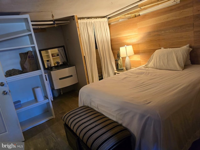 bedroom featuring wood walls