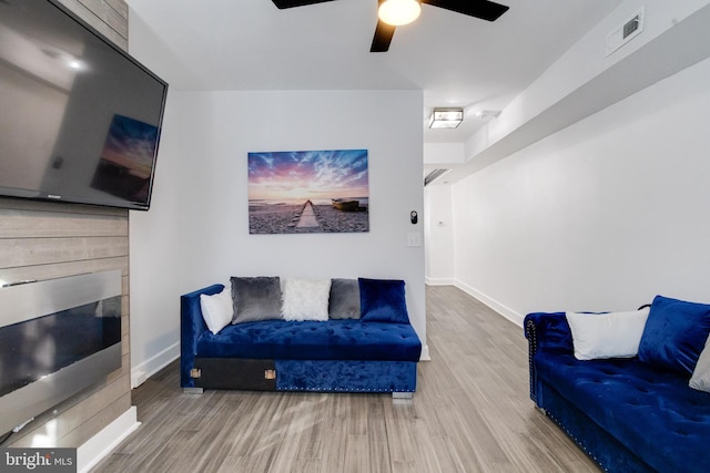 living room with wood-type flooring and ceiling fan