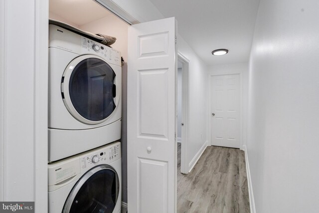 1107 S Carey St, Baltimore, MD 21223 - washroom with stacked washer / dryer, baseboards, and light wood-type flooring
