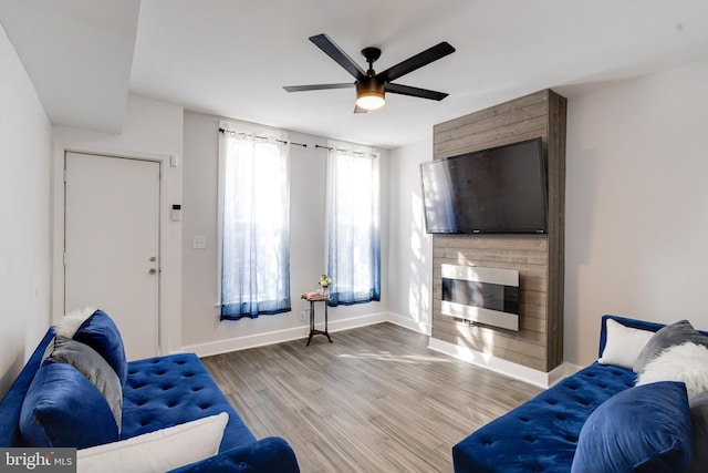 1107 S Carey St, Baltimore, MD 21223 - living area featuring a glass covered fireplace, ceiling fan, wood finished floors, and baseboards