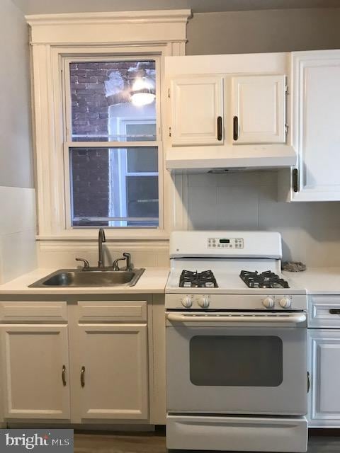 kitchen featuring white cabinets, gas range gas stove, sink, and dark hardwood / wood-style flooring