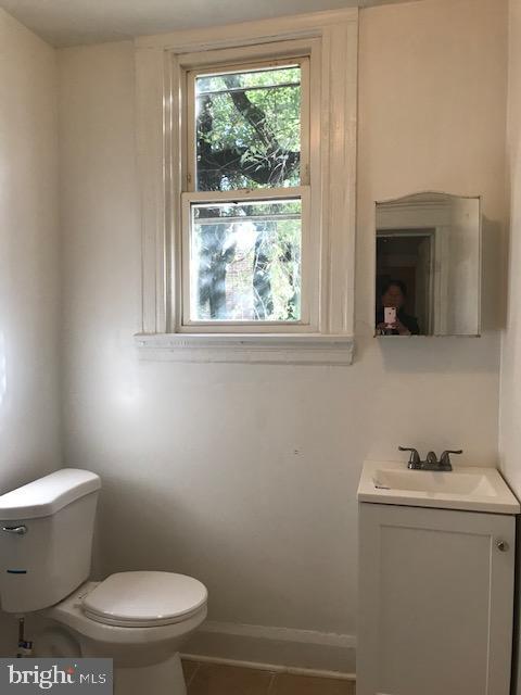 bathroom featuring toilet, vanity, and tile patterned floors