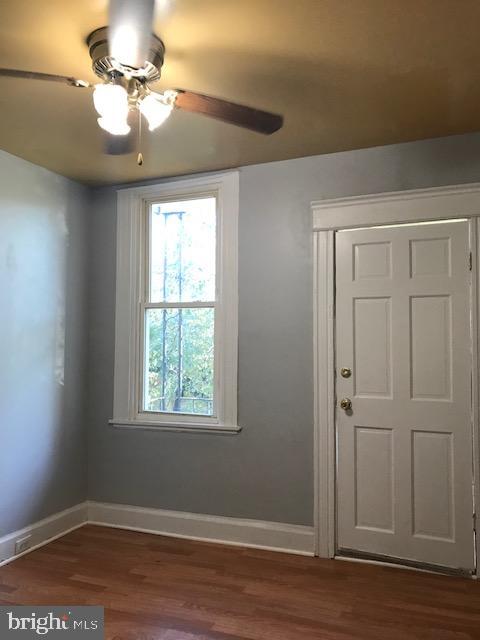 unfurnished room with ceiling fan and dark hardwood / wood-style floors