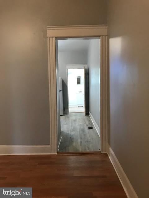 corridor with hardwood / wood-style floors