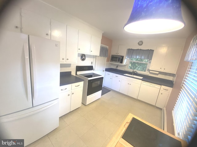 kitchen featuring white appliances, a healthy amount of sunlight, and white cabinetry