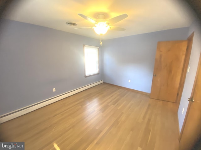 spare room with light hardwood / wood-style flooring, a baseboard heating unit, and ceiling fan