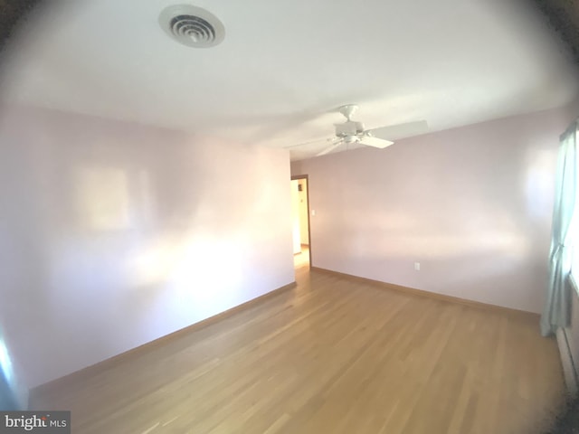 spare room featuring light hardwood / wood-style flooring and ceiling fan