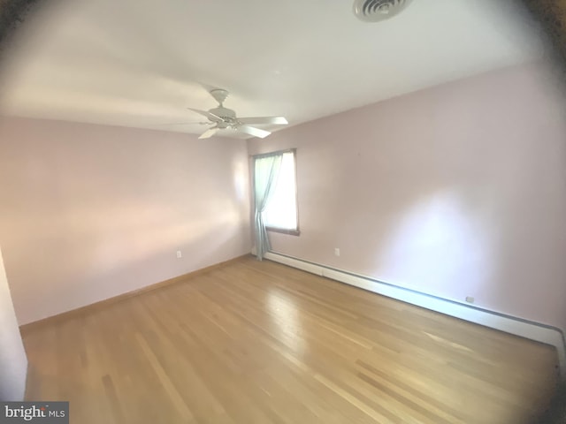 empty room featuring light hardwood / wood-style floors, baseboard heating, and ceiling fan