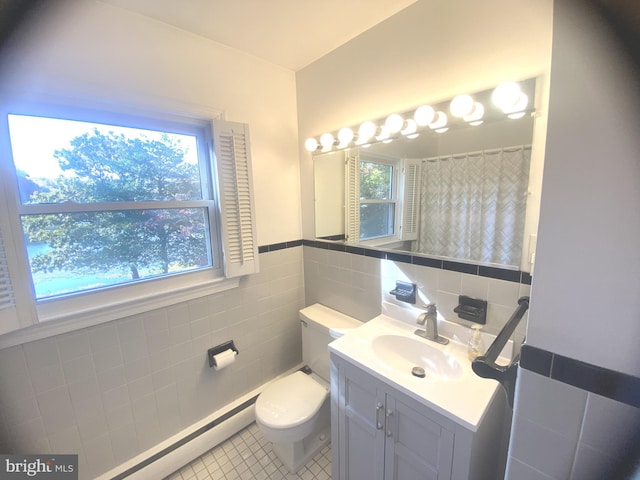 bathroom with vanity, toilet, a healthy amount of sunlight, and tile patterned flooring