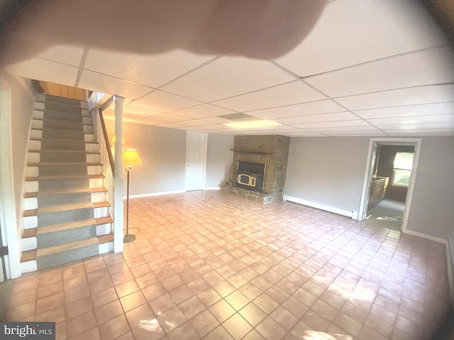 unfurnished living room featuring a wood stove and a paneled ceiling