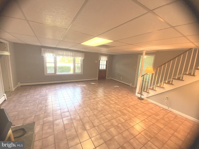 basement with a baseboard radiator and a drop ceiling