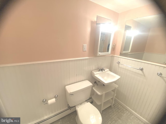 bathroom with toilet, baseboard heating, and sink