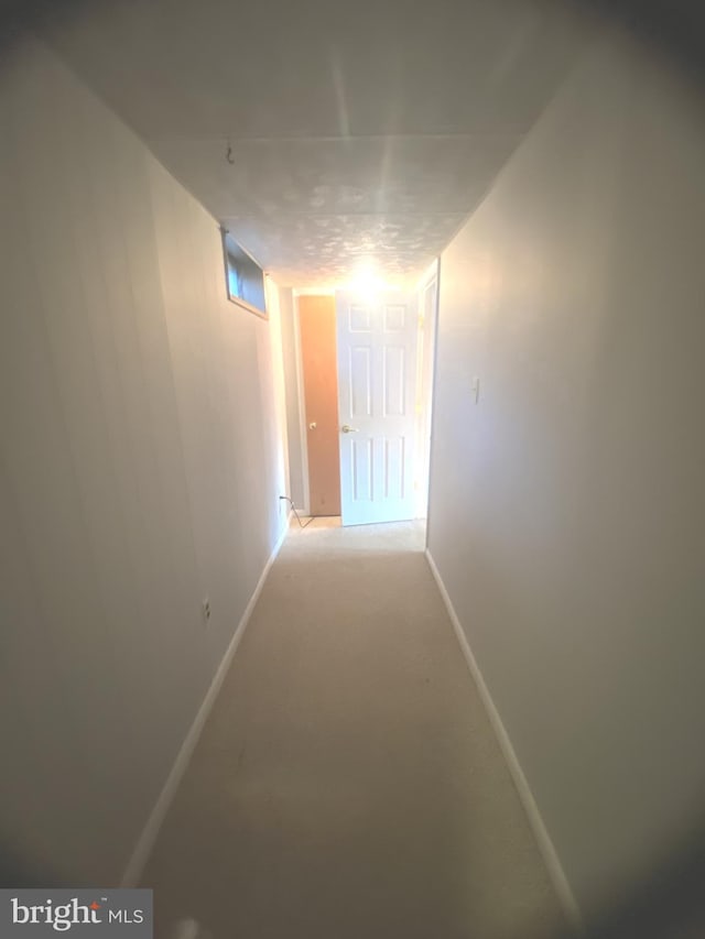 hallway featuring light colored carpet