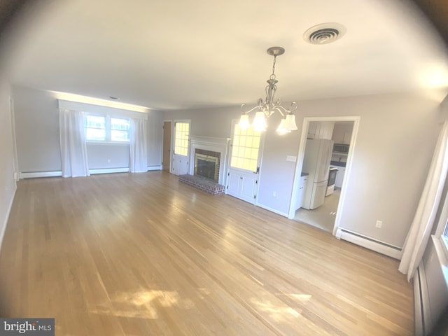 unfurnished living room featuring a baseboard heating unit, light hardwood / wood-style flooring, and a brick fireplace