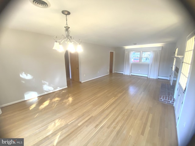 unfurnished room with light hardwood / wood-style floors, a chandelier, and a baseboard radiator