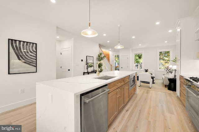 kitchen with a spacious island, light hardwood / wood-style flooring, appliances with stainless steel finishes, decorative light fixtures, and light stone counters